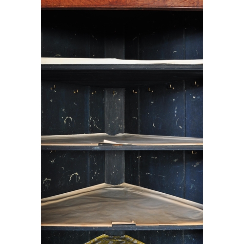 1591 - An 18th century George III country oak double corner cupboard. Raised on bracket feet with twin cupb... 