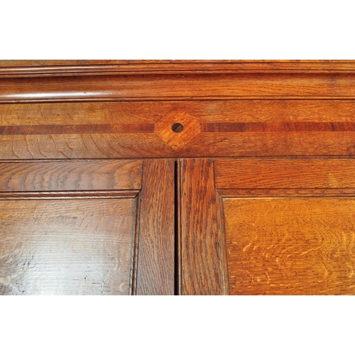 1591 - An 18th century George III country oak double corner cupboard. Raised on bracket feet with twin cupb... 