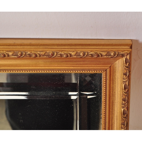 1609 - Gilt framed bevelled edge wall mirror of rectangular form having bevelled edge mirror glass to centr... 