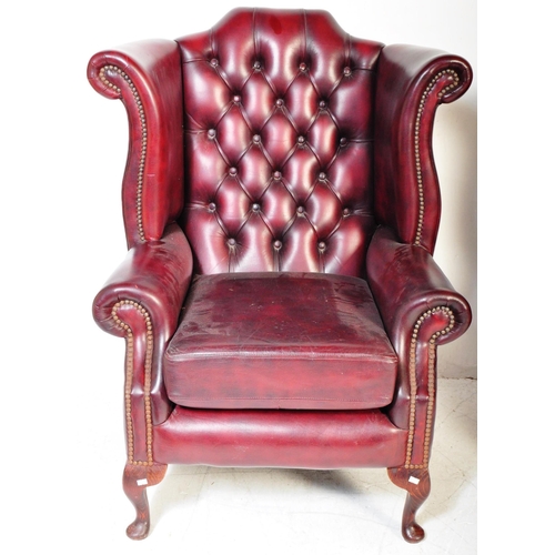 1613 - A pair of 20th Century Chesterfield - Queen Anne armchairs. In oxblood leather colour way with wing ... 