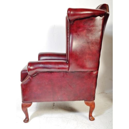 1613 - A pair of 20th Century Chesterfield - Queen Anne armchairs. In oxblood leather colour way with wing ... 