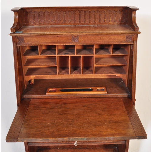 1628 - 1920's oak Arts & Crafts student bureau desk. The upright body with a series of shelves under fall f... 