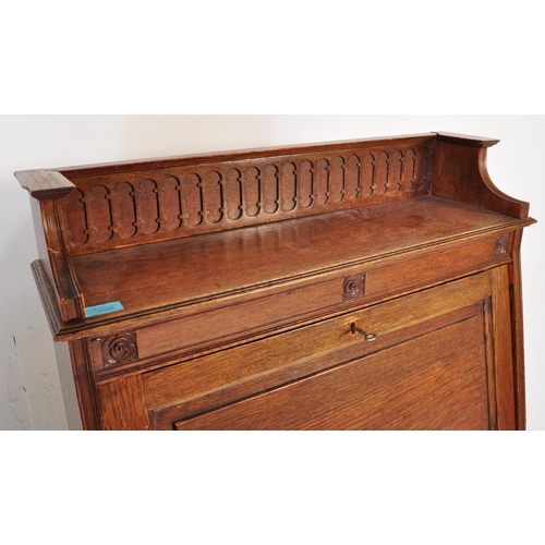 1628 - 1920's oak Arts & Crafts student bureau desk. The upright body with a series of shelves under fall f... 