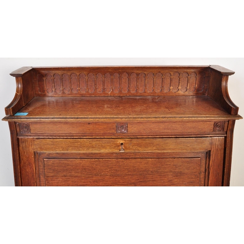 1628 - 1920's oak Arts & Crafts student bureau desk. The upright body with a series of shelves under fall f... 