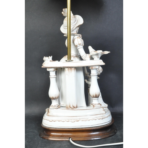 1666 - A vintage 20th century porcelain figural table lamp. The lamp base being modelled as a lady in hat a... 