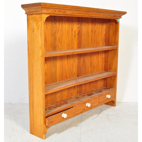 1677 - A 20th Century pine shelving unit / bookcase. The unit having a flared top with three shelves and th... 