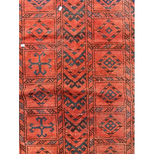 1467 - A vintage 20th Century Turkmenistan Bukhara floor carpet rug. Having two central geometrical strips ... 