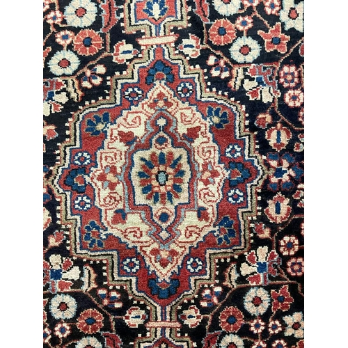 1500 - An early 20th century Persian Islamic North West Sarouk floor carpet rug having a central medallion ... 