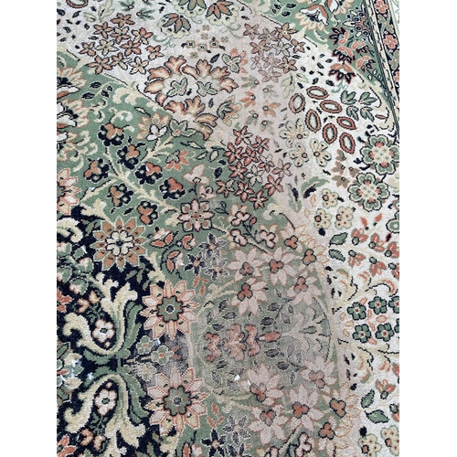 1503 - A mid 20th century Persian Islamic Shiraz floor carpet rug on green tones ground with central floral... 