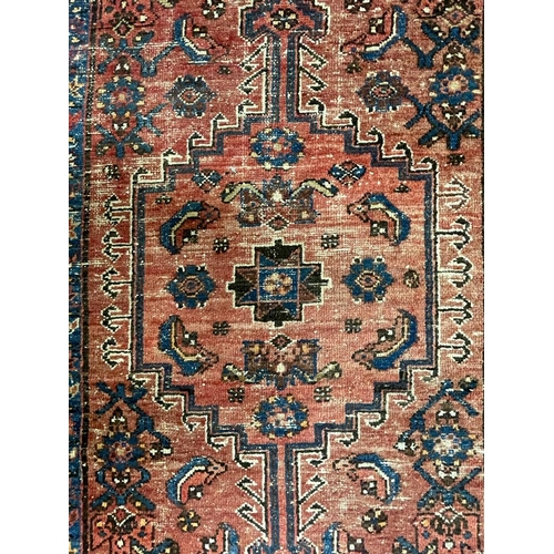 1560 - An early 20th century Persian Islamic Hamada runner floor carpet rug having a red ground central pan... 