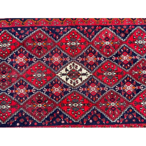 1561 - An early 20th century Persian Islamic Veramin runner floor carpet rug having a series of repeating d... 