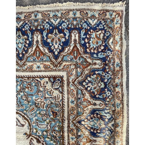 1636 - An 20th Century Kirman Persian Islamic floor carpet rug having a central panel in cream and light bl... 