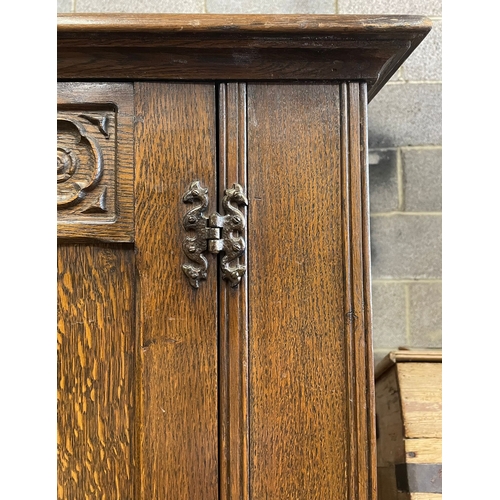 1660 - A vintage 20th century Jacobean Revival oak bedroom wardrobe having a flared top over two tall twin ... 