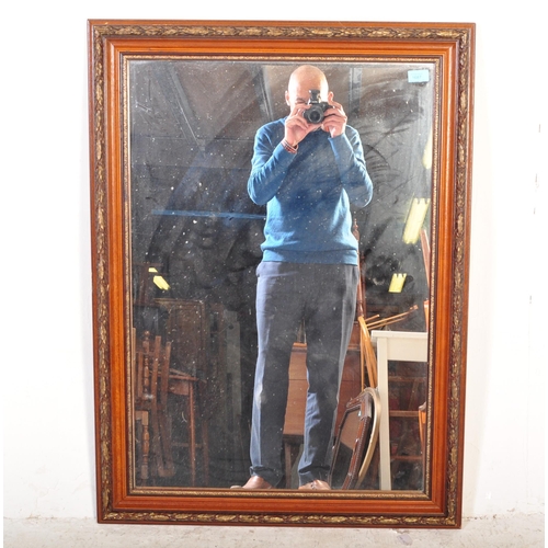 1687 - A large 20th century overmantel wall mirror. The rectangular mirror framed in mahogany being carved ... 