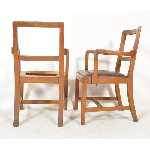 1688 - A pair of 1930s oak framed carver chairs. The chairs having rounded back rests with shaped arms rest... 