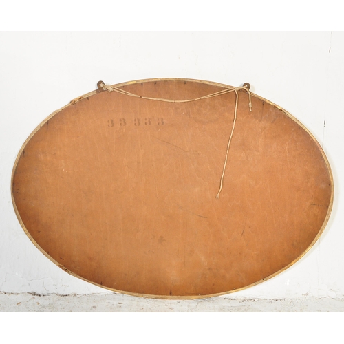 1694 - A vintage retro 20th century oval wall hanging mirror having gilt frame with decorative moulding to ... 