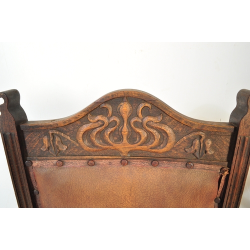 1734 - A late 19th Century Arts & Crafts oak carved hall chair. Having an arched carved top flanked by fini... 