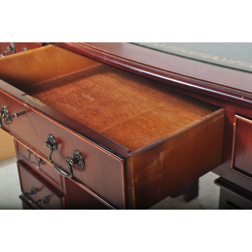 1751 - A 20th century mahogany twin pedestal office desk having a shaped top with central green leather pan... 