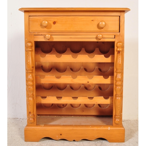 1762 - A 20th Century wine / bottle rack cabinet with draw and pull out serving leaf. The pine cabinet with... 