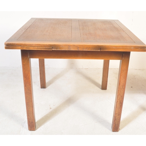 1712 - A 1930's oak refectory draw leaf dining table and set of 4 chairs. The table with squared chamfered ... 