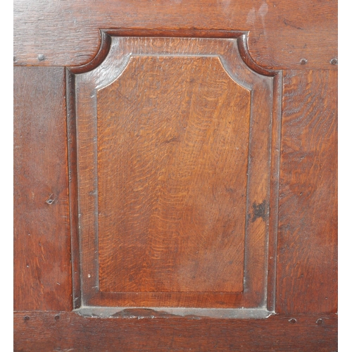 86 - A 19th Century carved oak settle bench having a fielded panel back with large armrests and red velou... 