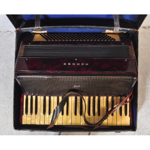 1114 - A vintage 20th century circa. 1940's Hohner accordion musical instrument having red Lucite type case... 