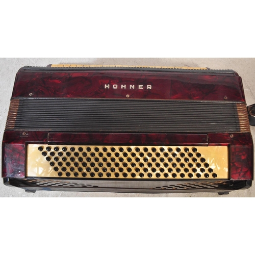 1114 - A vintage 20th century circa. 1940's Hohner accordion musical instrument having red Lucite type case... 