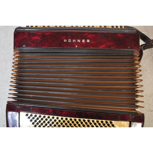 1114 - A vintage 20th century circa. 1940's Hohner accordion musical instrument having red Lucite type case... 