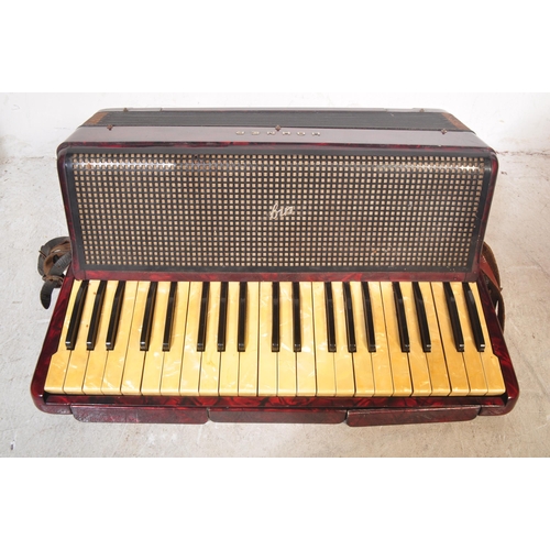 1114 - A vintage 20th century circa. 1940's Hohner accordion musical instrument having red Lucite type case... 