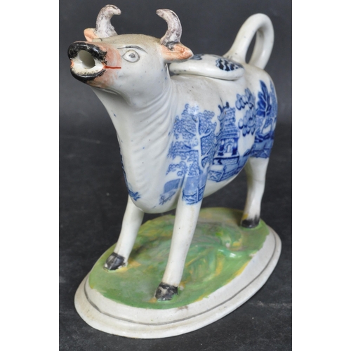 615A - A 19th century Staffordshire porcelain cow creamer. Blue and white willow pattern to the body with g... 