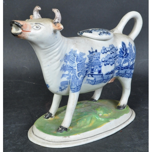 615A - A 19th century Staffordshire porcelain cow creamer. Blue and white willow pattern to the body with g... 