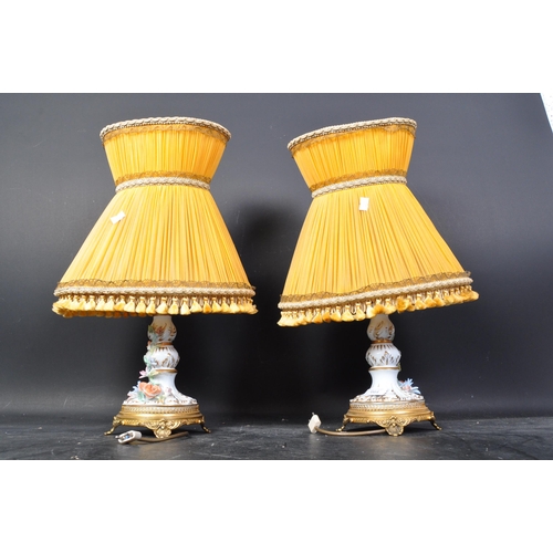 664 - A pair of 20th century German Sitzendorf porcelain lamp bases, each having a white ground and being ... 