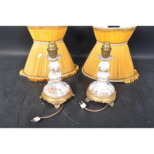 664 - A pair of 20th century German Sitzendorf porcelain lamp bases, each having a white ground and being ... 