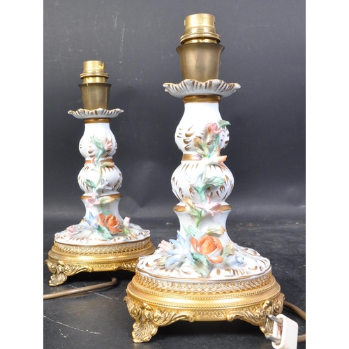 664 - A pair of 20th century German Sitzendorf porcelain lamp bases, each having a white ground and being ... 