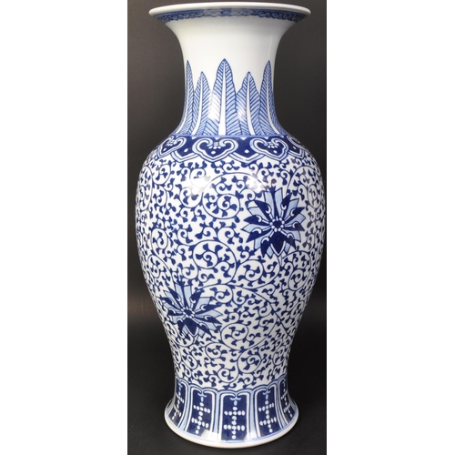 671 - A large vintage 20th century Chinese blue and white vase of baluster form. The vase having florals a... 