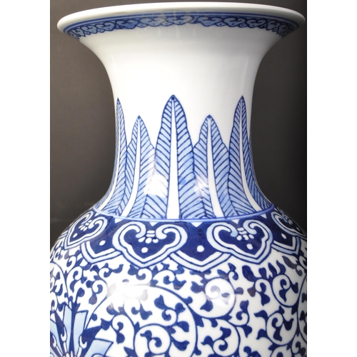 671 - A large vintage 20th century Chinese blue and white vase of baluster form. The vase having florals a... 