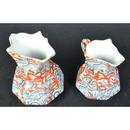 690A - A pair of Masons Ironstone graduating Hydra jugs with orange grounds and geometric decoration, serpe... 