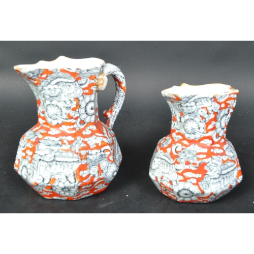 690A - A pair of Masons Ironstone graduating Hydra jugs with orange grounds and geometric decoration, serpe... 