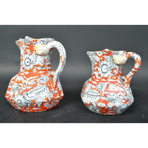 690A - A pair of Masons Ironstone graduating Hydra jugs with orange grounds and geometric decoration, serpe... 