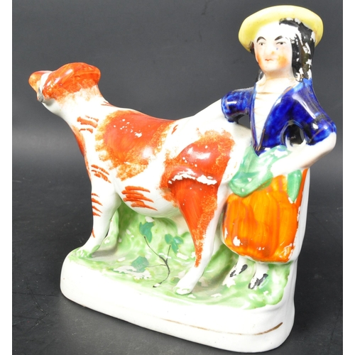 725a - A 19th Century Staffordshire figurine of cow and milk maid. Measures approx. Together with a wooden ... 