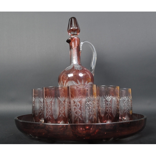 769 - A 20th Century cranberry glass decanter tray and drinking glasses. Having a pink and clear colourway... 