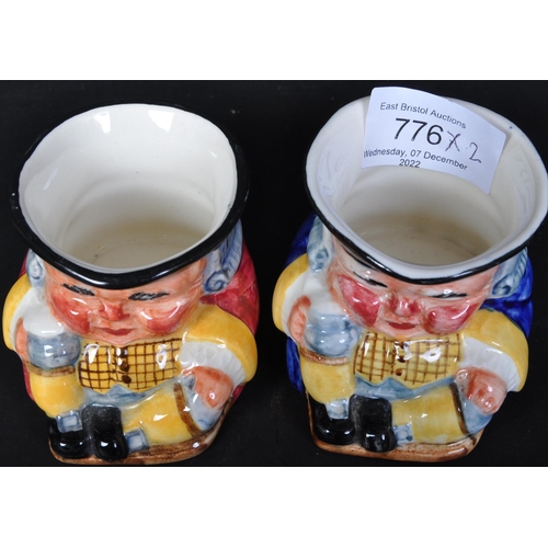 776 - A pair of 20th century Clarice Cliff pottery miniature toby jugs with blue & red gilets holding stei... 