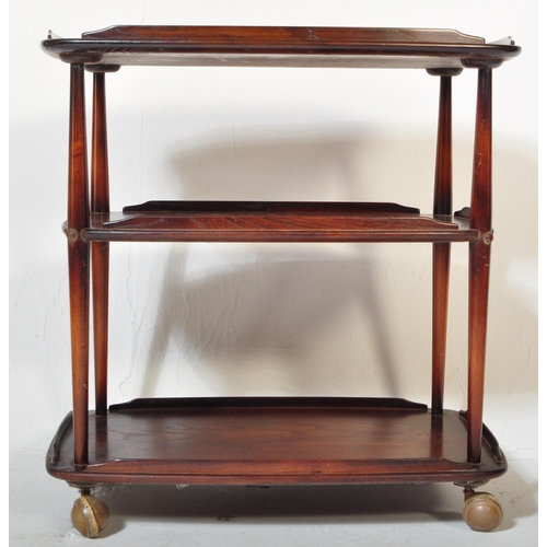 1152 - An Ercol vintage retro 20th Century dark elm wood tiered serving trolley. Of rectangular form with g... 