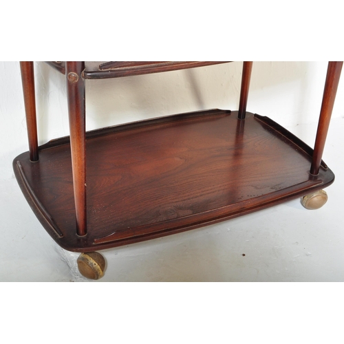 1152 - An Ercol vintage retro 20th Century dark elm wood tiered serving trolley. Of rectangular form with g... 