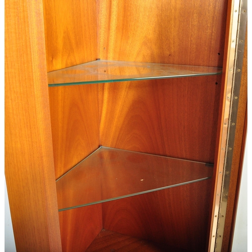 1186 - A vintage retro mid 20th teak upright corner cabinet having pediment over a single glazed door openi... 