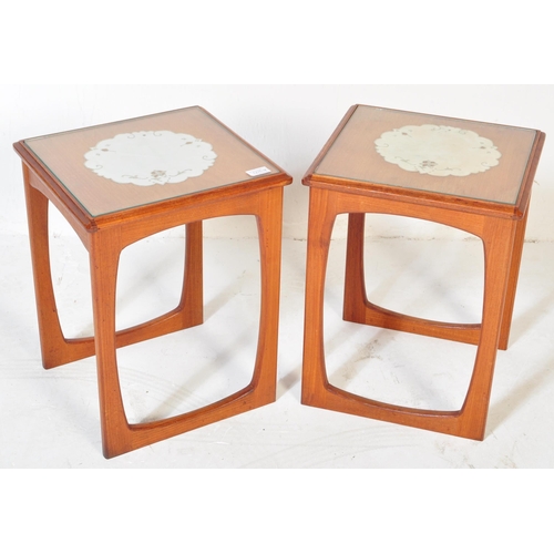 1220 - A pair of vintage retro mid 20th century teak side tables. Each having glazed top with white underla... 