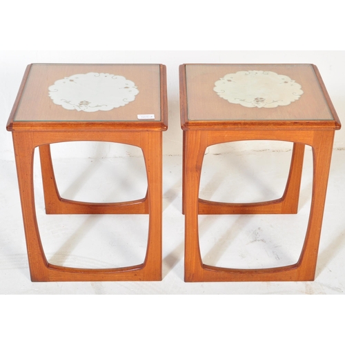 1220 - A pair of vintage retro mid 20th century teak side tables. Each having glazed top with white underla... 