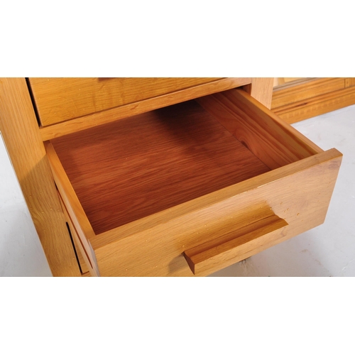 1221 - A contemporary oak bedside chest of drawers in the manner of Oak furniture Land  Raised on squared l... 