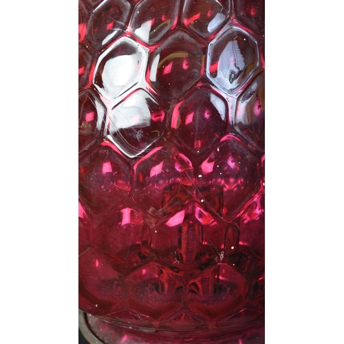 1226 - A vintage retro mid 20th century oil lamp having globular moulded cranberry glass shade over twin ha... 