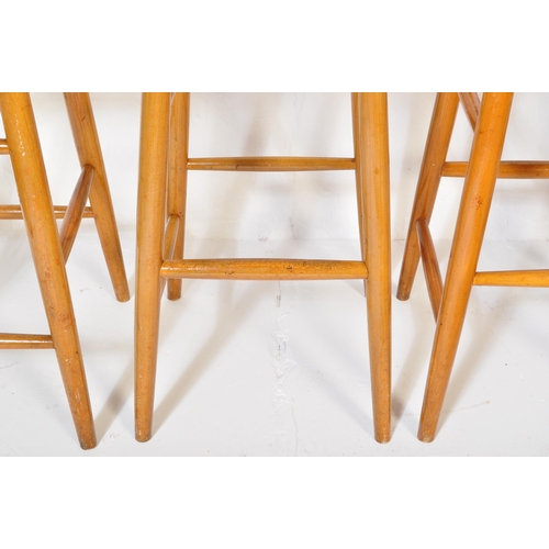 1253 - A set of four retro vintage mid 20th Century Ercol style bar stools light wood chamfered dowel legs,... 